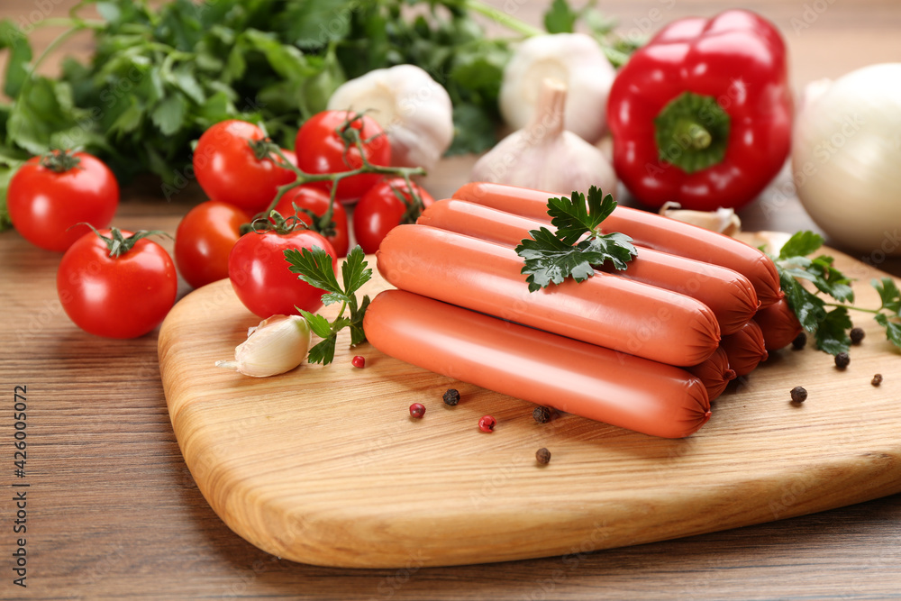 Fresh raw vegetarian sausages with parsley and vegetables on wooden table Fresh raw vegetarian sausages with parsley and vegetables on wooden table