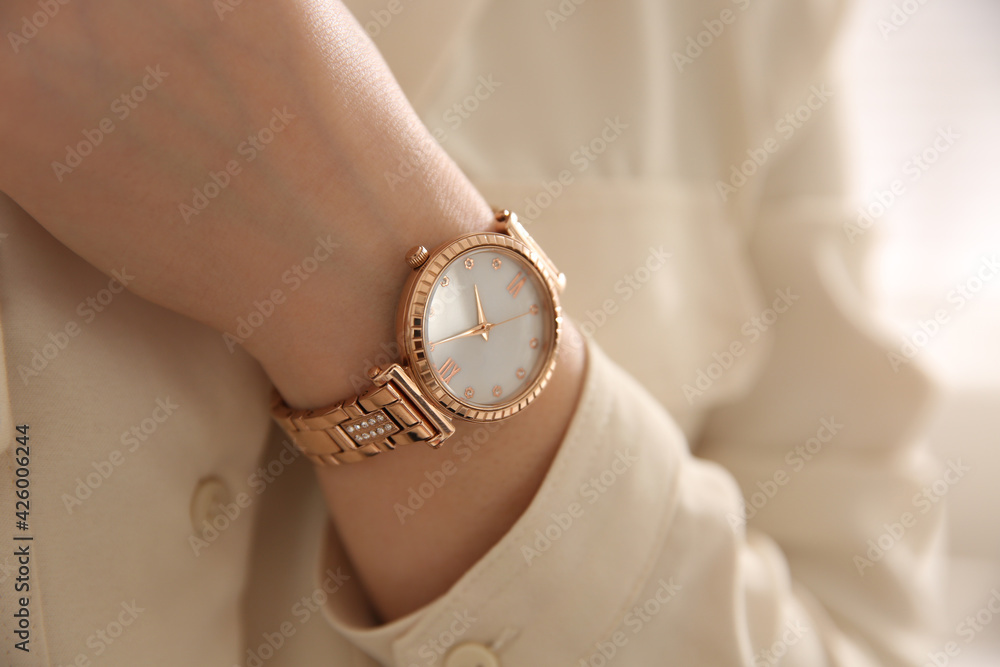 Woman with luxury wristwatch on light background, closeup - obrazy, fototapety, plakaty 