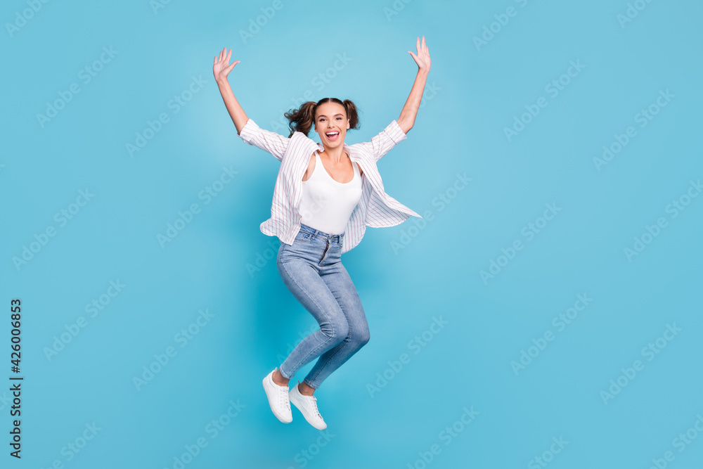 Full length body size view of attractive sporty cheerful girl jumping having fun good day isolated on bright blue color background