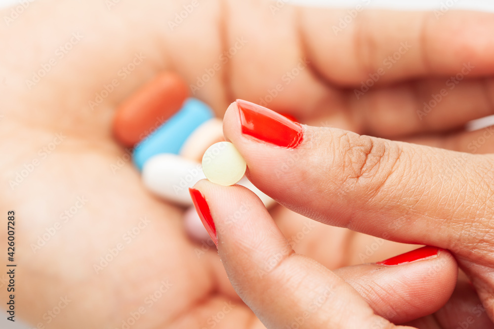 Macro Close up of medicinal or herbal multi-color tablet, capsule, and pill on a female hand palm. Top view, Macro Close up of medicinal or herbal multi-color tablet, capsule, and pill on a female hand palm. Top view,