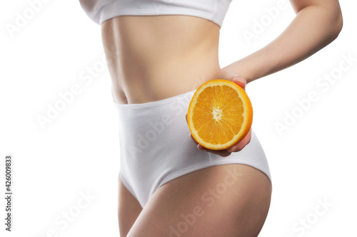 Beauty portrait of a lovely young woman with long blonde hair showing slices of an orange