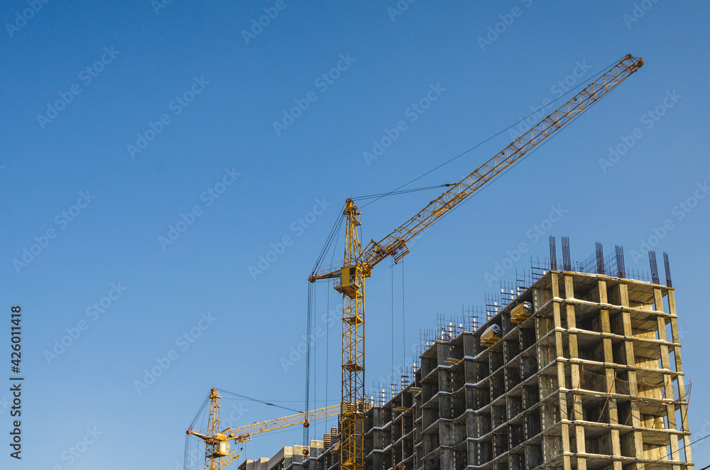 Crane on a construction site against a blue sky background