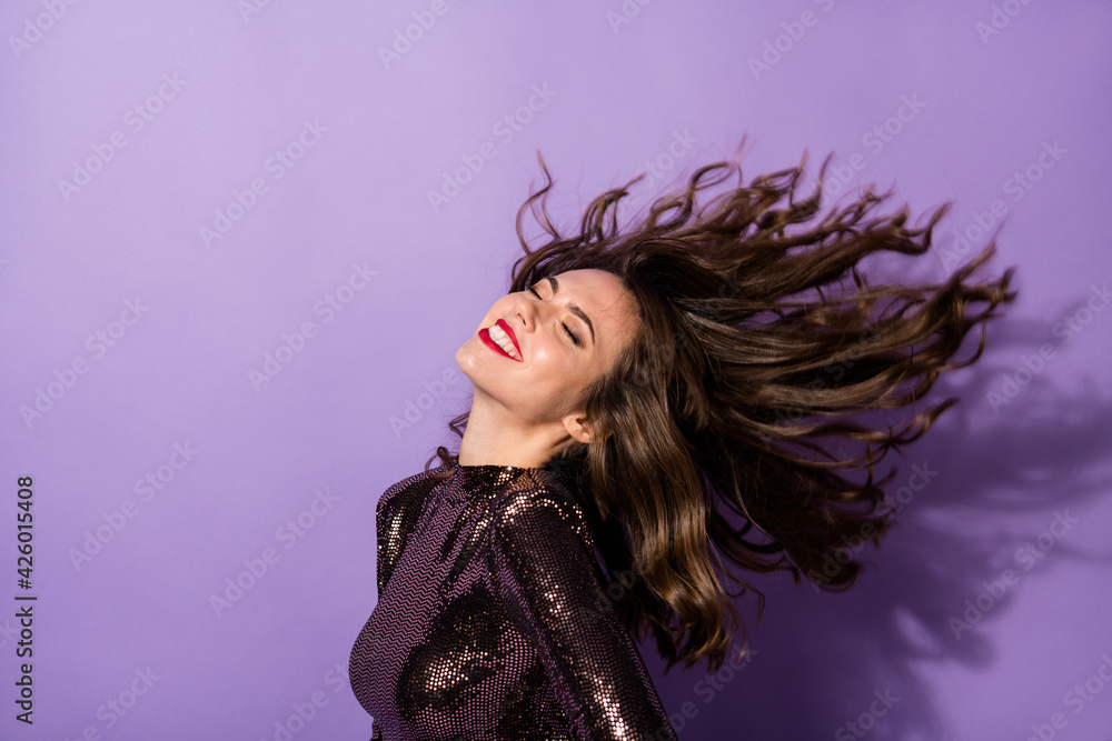 Portrait of attractive chic cheerful dreamy girl wind blowing hair isolated over bright violet color background Portrait of attractive chic cheerful dreamy girl wind blowing hair isolated over bright violet color background