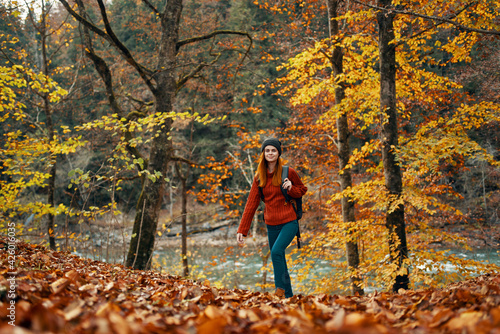 woman travels in autumn forest in nature landscape yellow leaves on trees tourism river lake