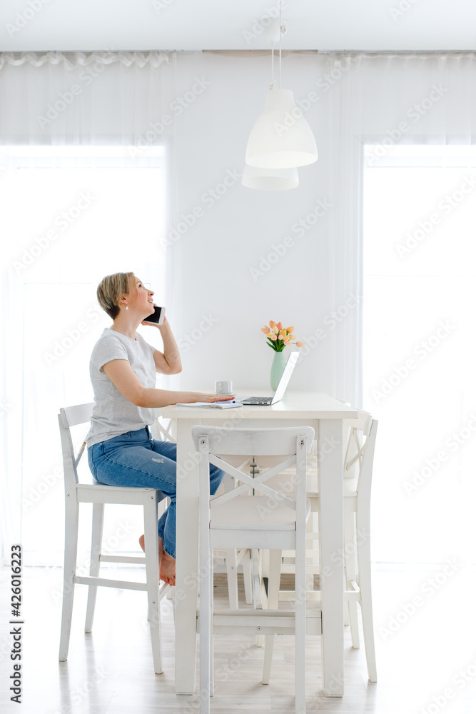 woman working on laptop and talking on the phone woman working on laptop and talking on the phone