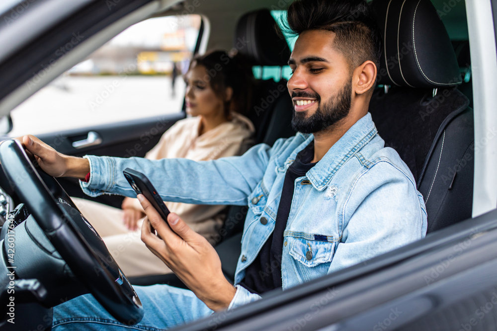 Traveler young indian couple use smart phone while driving car Traveler young indian couple use smart phone while driving car