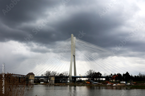 Piękny linowy most drogowy nad rzeką w burzową pogodę. 