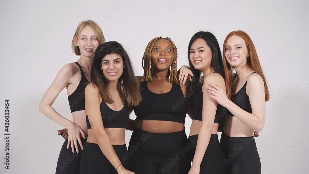 Diverse models showing thumbs up isolated on white background, smile at camera, wearing black sportive outfit. Diverse models showing thumbs up isolated on white background, smile at camera, wearing black sportive outfit.