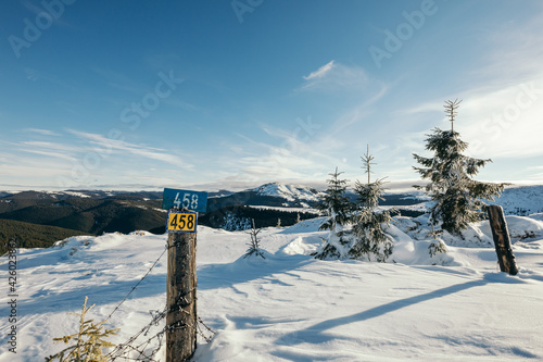 A sign on the side of a snow covered slope