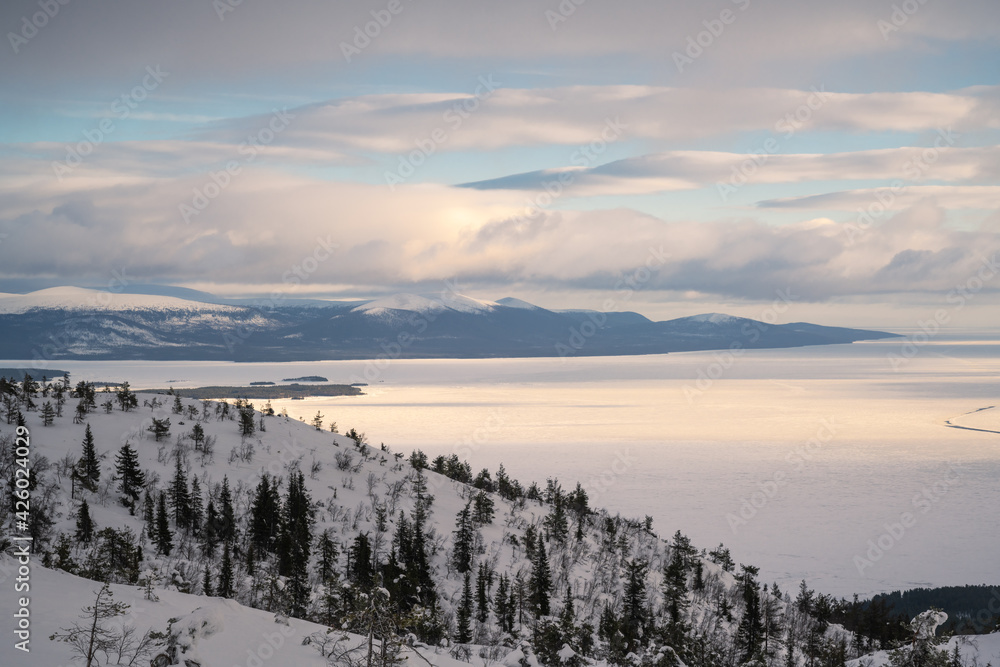 Xinjiang, China, frozen lake, natural scenery in winter, cloudy weather.