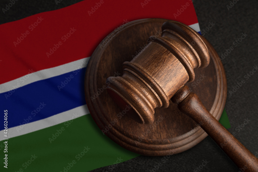 Judge gavel and flag of Gambia. Law and justice in Gambia. Violation of rights and freedoms