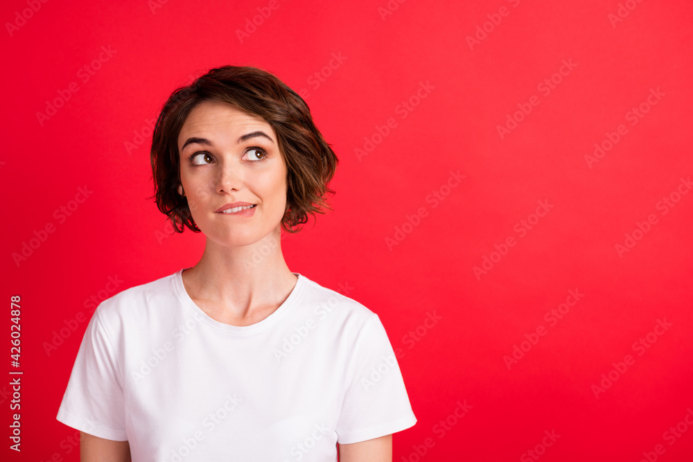 Portrait of attractive cheerful curious girl thinking copy empty blank space biting lip isolated over vibrant red color background Portrait of attractive cheerful curious girl thinking copy empty blank space biting lip isolated over vibrant red color background
