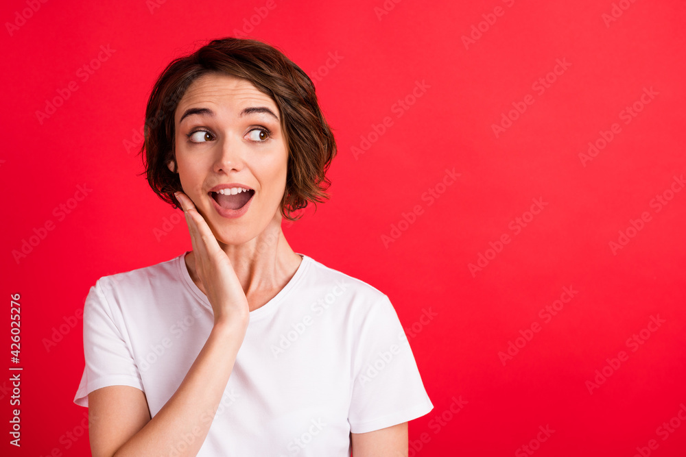Portrait of attractive amazed cheerful curious girl looking aside copy space wow sale reaction isolated over bright red color background Portrait of attractive amazed cheerful curious girl looking aside copy space wow sale reaction isolated over bright red color background