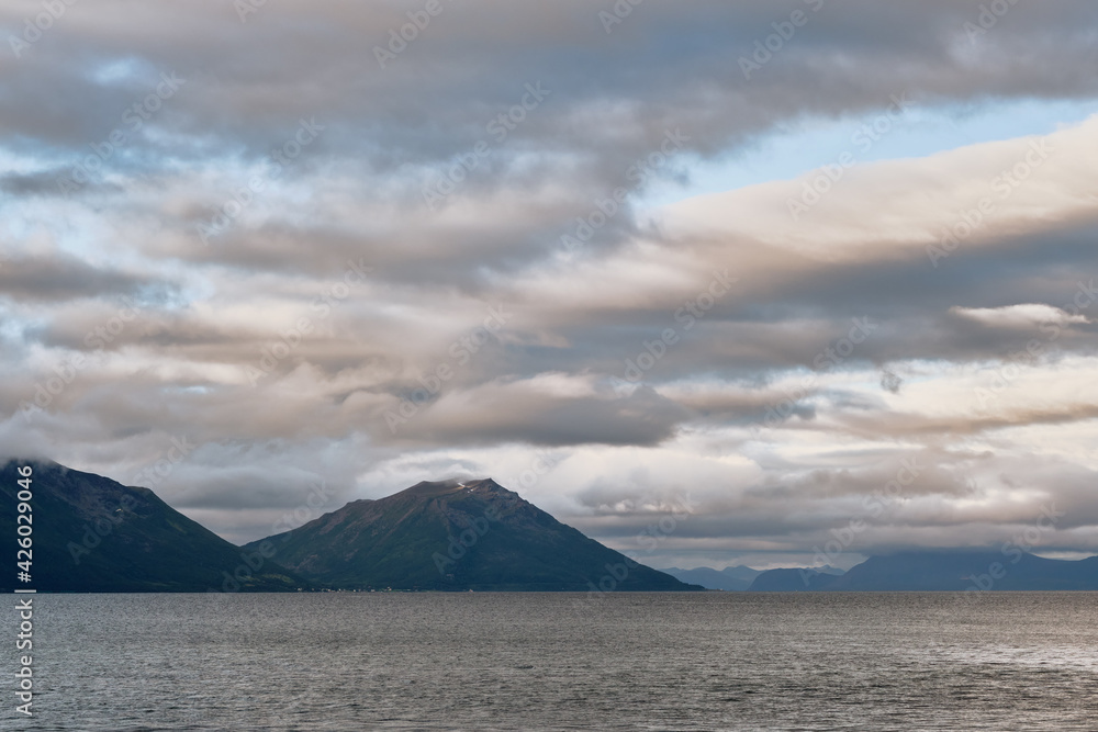 View of clouds and mountains over the sea in Norway