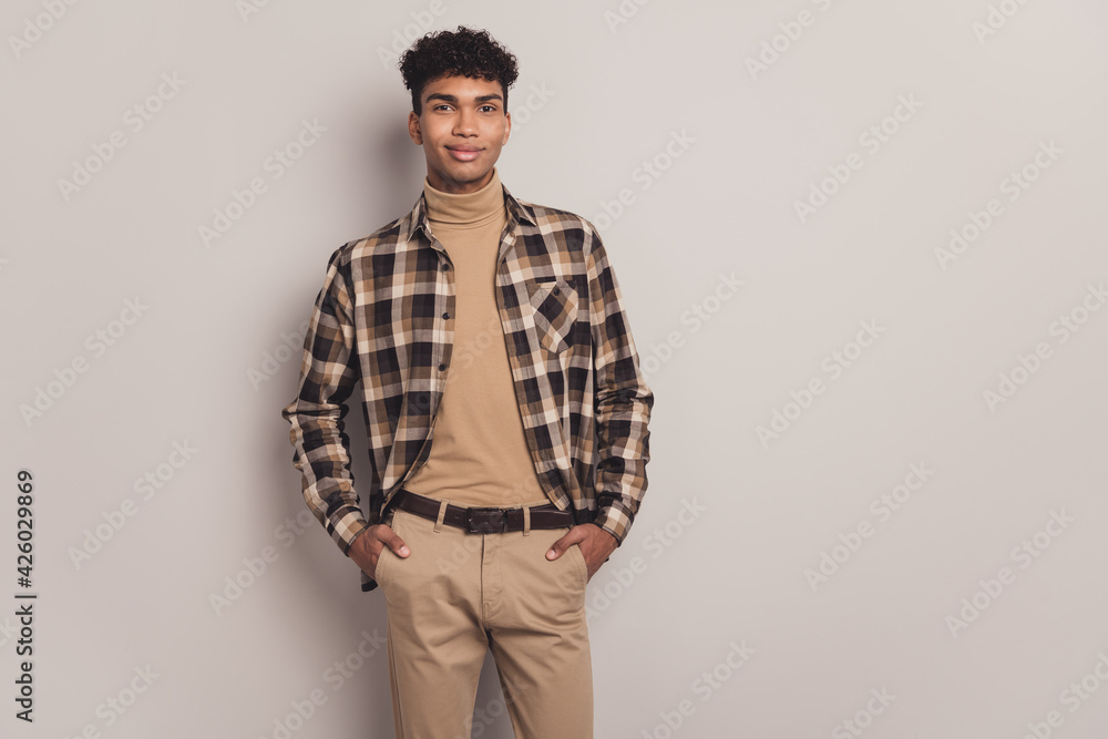 Photo of calm guy hands pockets look camera wear checkered shirt turtleneck pants isolated grey color background Photo of calm guy hands pockets look camera wear checkered shirt turtleneck pants isolated grey color background