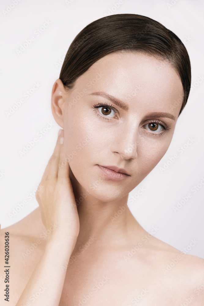 Young woman with beautiful healthy face - isolated on white background, studio hi-end shot, skin care concept. Hands and fingers gently touch facial skin, brown hair parted, gathered in low ponytail Young woman with beautiful healthy face - isolated on white background, studio hi-end shot, skin care concept. Hands and fingers gently touch facial skin, brown hair parted, gathered in low ponytail