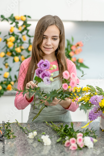 Young girl arranging flower at flower shop. Hobby and leisure concept