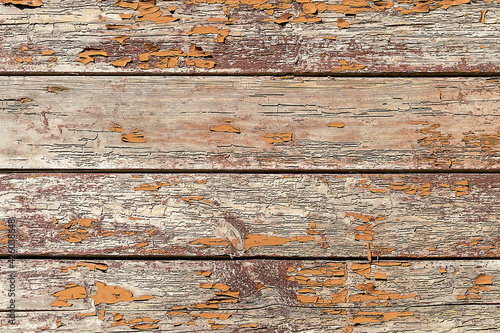 Wooden boards with a shabby orange paint background. Sunny autumn day. Front view.