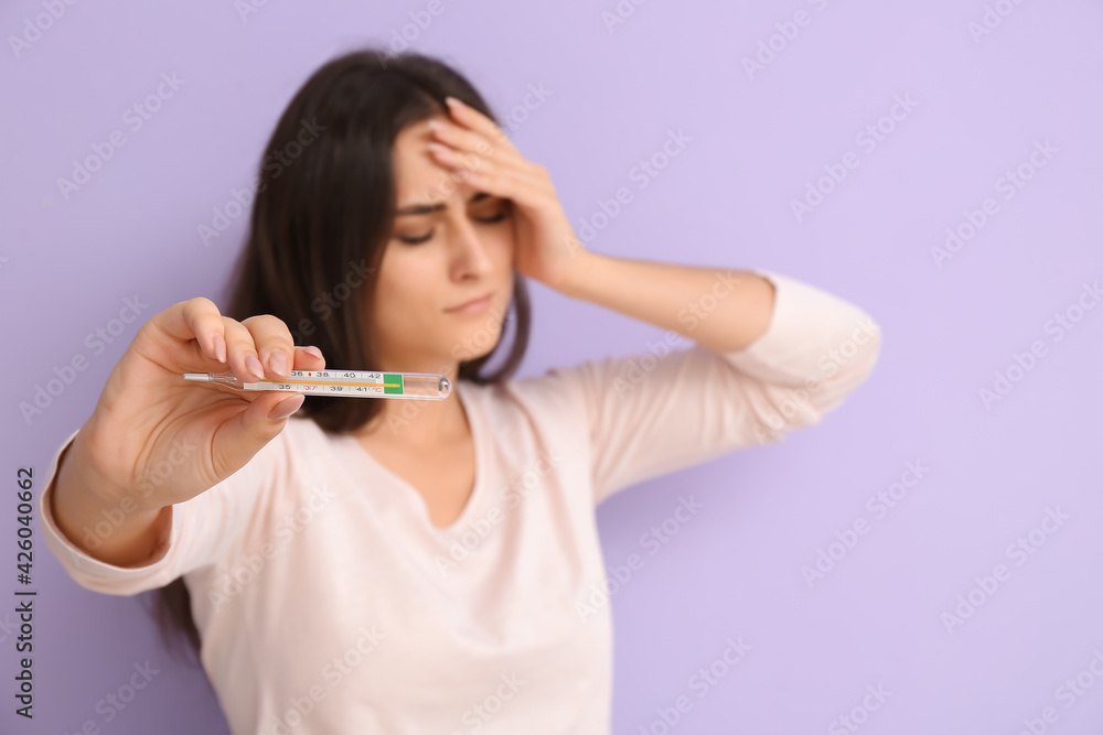 Sick young woman with thermometer on color background Sick young woman with thermometer on color background