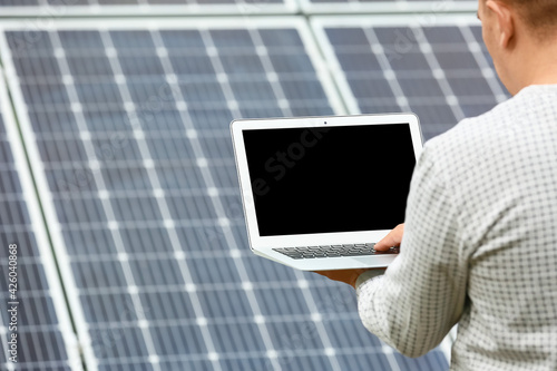 Man with laptop near solar ...