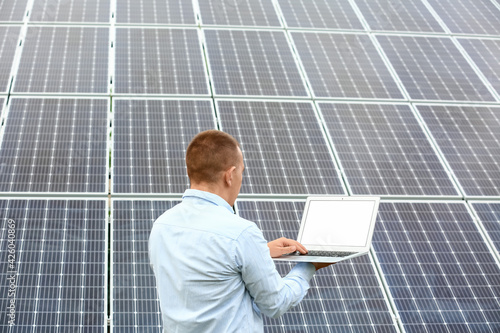 Man with laptop near solar ...