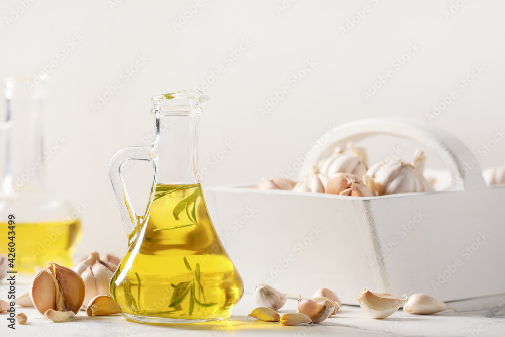 Jug of garlic oil on light background Jug of garlic oil on light background