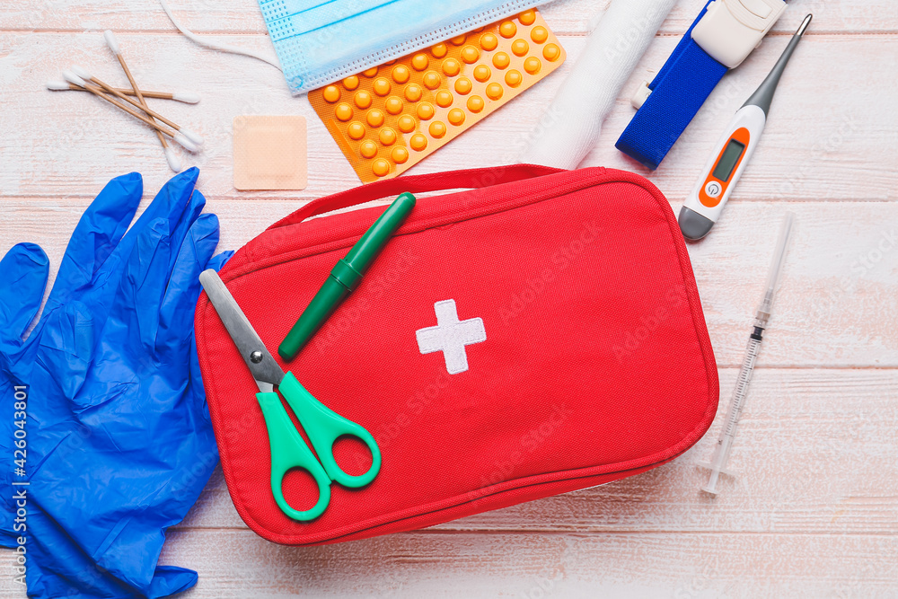 Naklejka premium First aid kit on wooden background