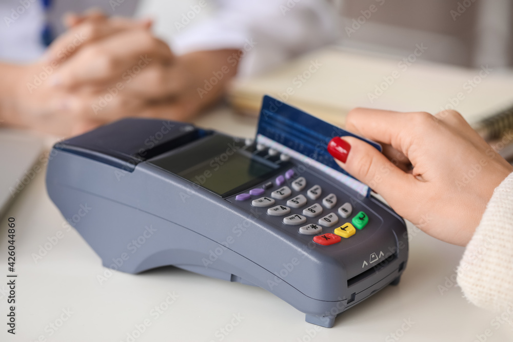 Patient paying for consultation in clinic via terminal, closeup Patient paying for consultation in clinic via terminal, closeup