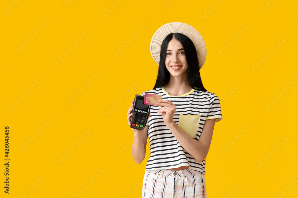 Young woman with payment terminal and credit card on color background Young woman with payment terminal and credit card on color background
