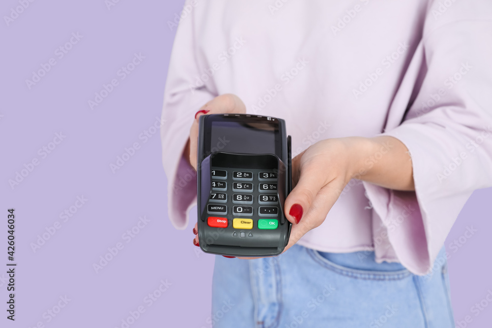Young woman with payment terminal on color background, closeup Young woman with payment terminal on color background, closeup