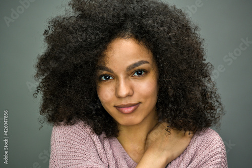 Close up horizontal portrait of beautiful young black woman on gray background.