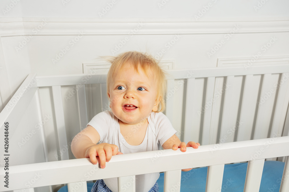 Cute laughing baby boy stand in the crib Cute laughing baby boy stand in the crib