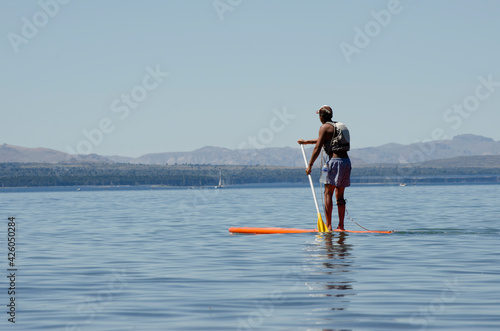 Stand Up Paddle Surfing, young man on board in lake © Lautaro