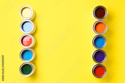 Cans of paints on color bac...