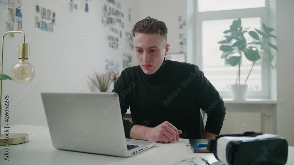 Young man conducts video call in co-working space in office Young man conducts video call in co-working space in office