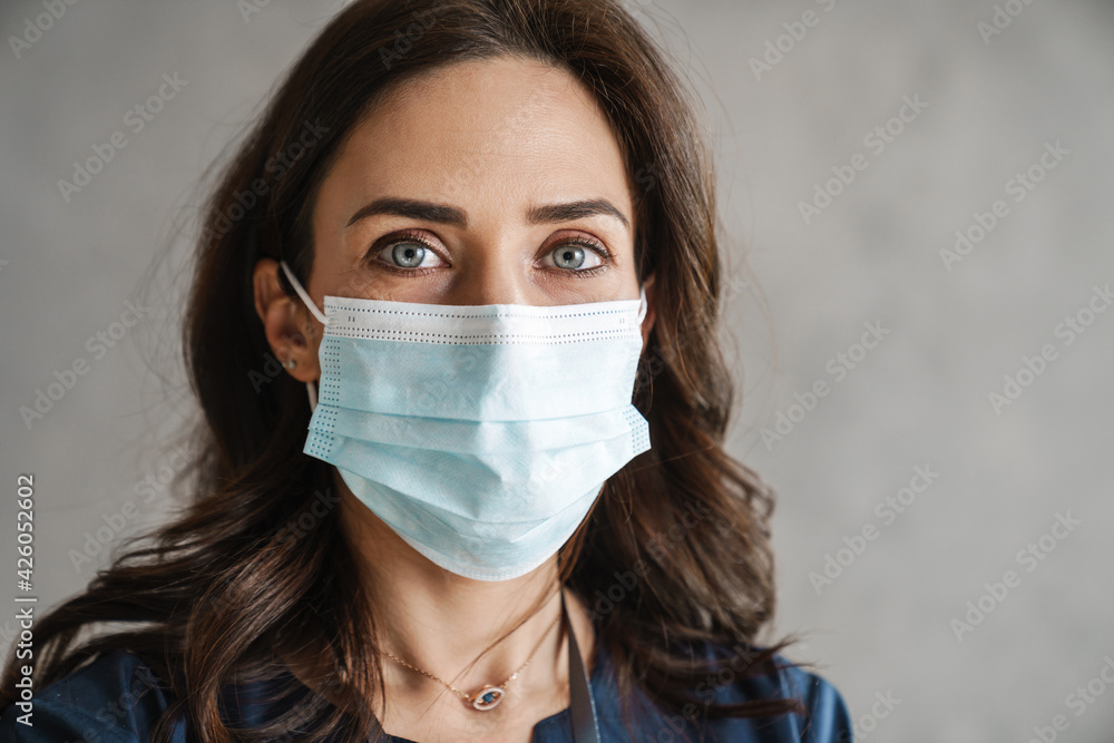 Confident mid aged woman doctor in protective medical mask Confident mid aged woman doctor in protective medical mask