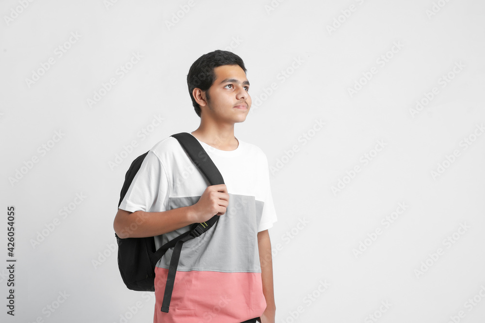 Young indian college student holding bag on white background. Young indian college student holding bag on white background.