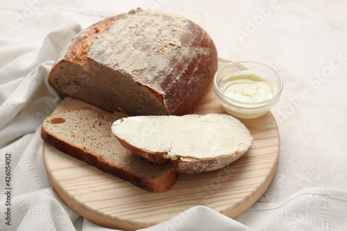 Fresh bread with butter on light background