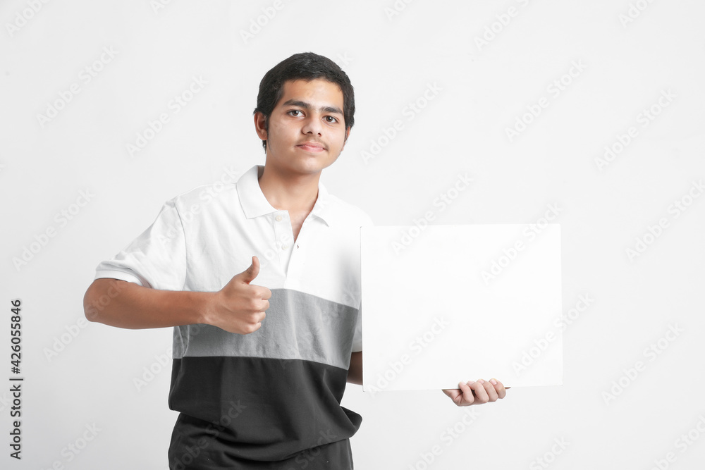 Young indian college student showing white board on white background Young indian college student showing white board on white background