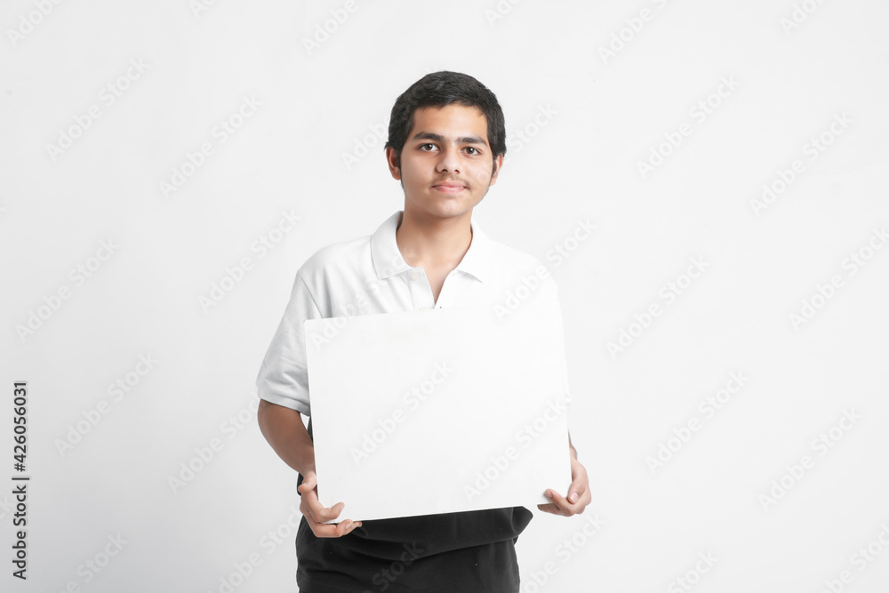 Young indian college student showing white board on white background Young indian college student showing white board on white background