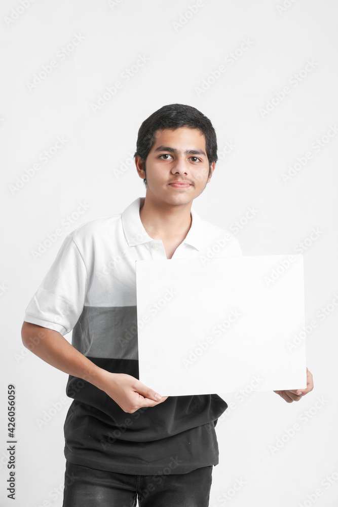 Young indian college student showing white board on white background Young indian college student showing white board on white background