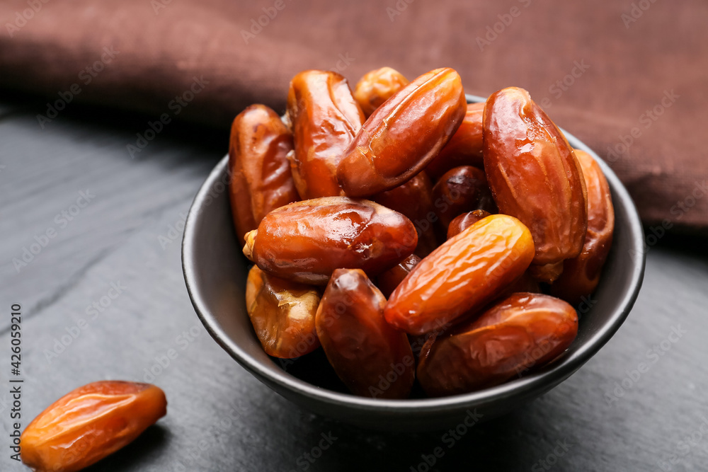 Bowl with sweet dried dates on dark wooden background, closeup Bowl with sweet dried dates on dark wooden background, closeup
