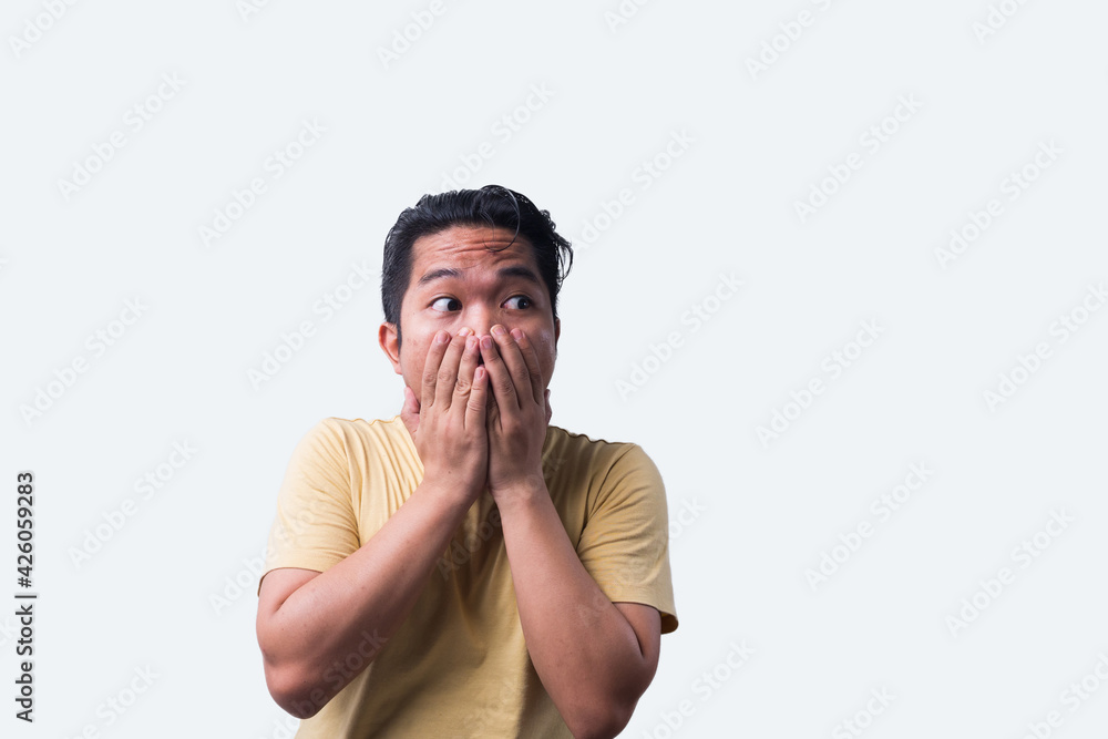 Face reaction, Asian young man portrait of face expression, shocked, thrilled, scared, surprised, with covered face with hand. Isolated, selective focus, copy space Face reaction, Asian young man portrait of face expression, shocked, thrilled, scared, surprised, with covered face with hand. Isolated, selective focus, copy space