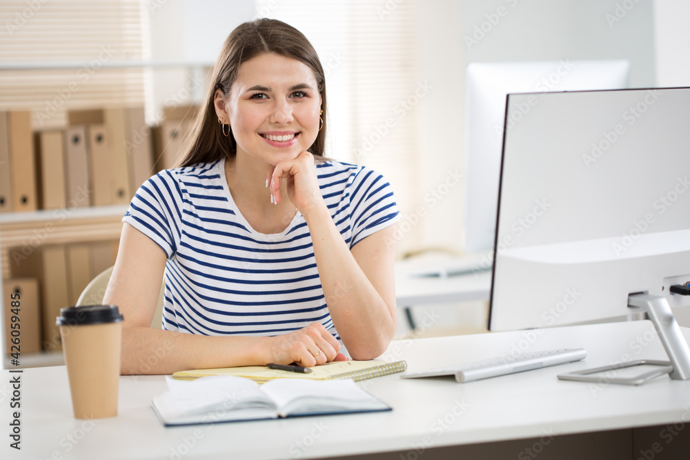 Portrait of business woman looking at camera at workplace in an office Portrait of business woman looking at camera at workplace in an office