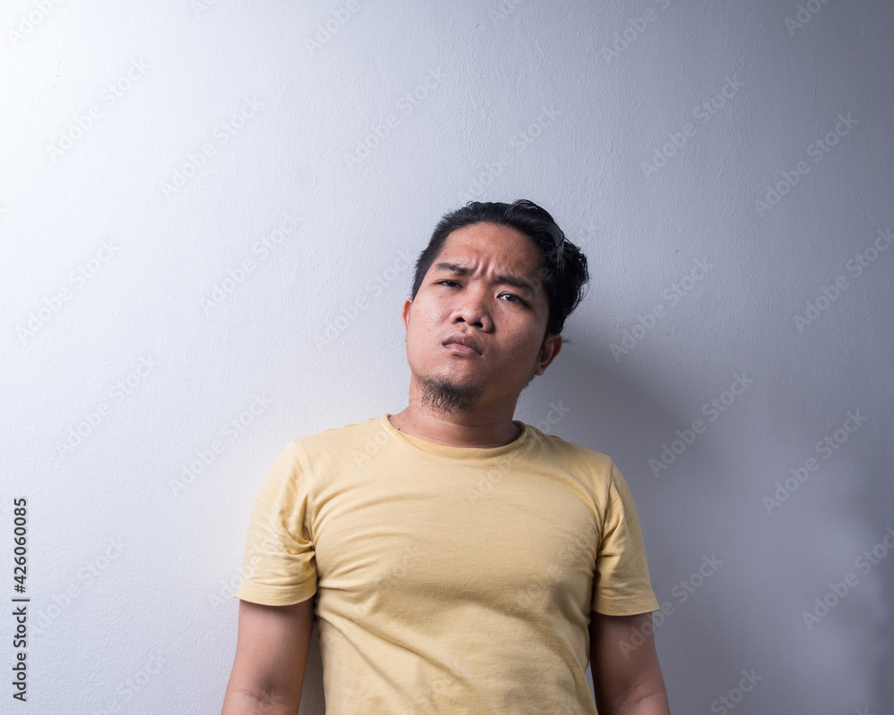 Portrait of Young Asian man with face expression, shocked, pointing finger, disappointment, weird and wow. Isolated background. Copy space, selective focus Portrait of Young Asian man with face expression, shocked, pointing finger, disappointment, weird and wow. Isolated background. Copy space, selective focus