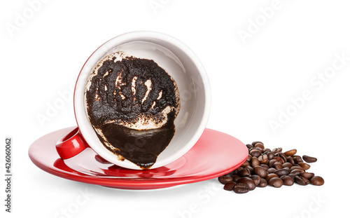 Cup with spent coffee grounds for fortune telling on white background photo