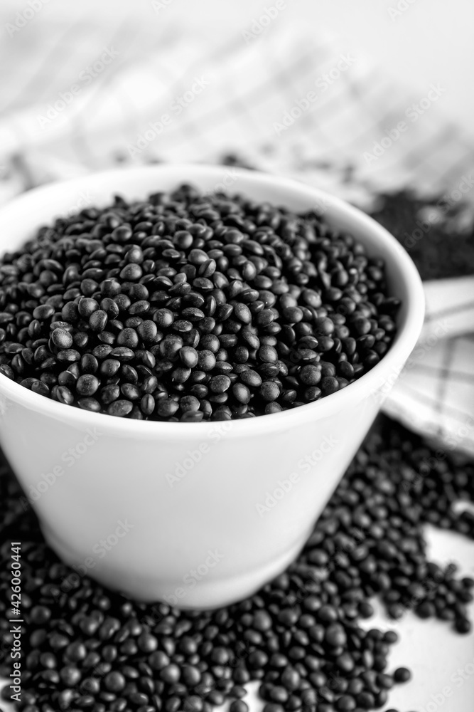 Bowl with black lentils on light background Bowl with black lentils on light background