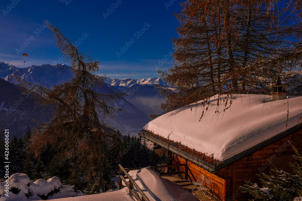 Landscape view of the ski and snowboard resort of Verbier, in Valais, Switzerland, with a traditional swiss chalet in the foreground