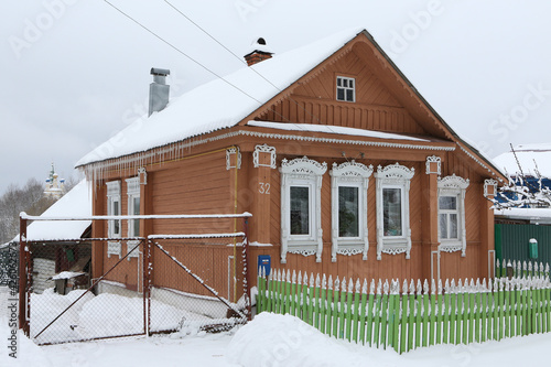 Vintage wooden rural house in Dunilovo village in Ivanovo region, Russia. Building facade; ornamental windows with carved frames. Russian traditional national folk style in architecture. Countryside photo