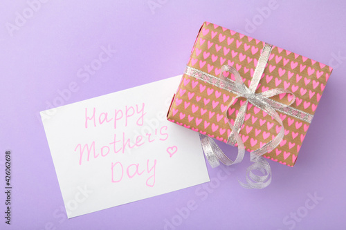 Mother's day card on purple background with a present. Happy Mother's day